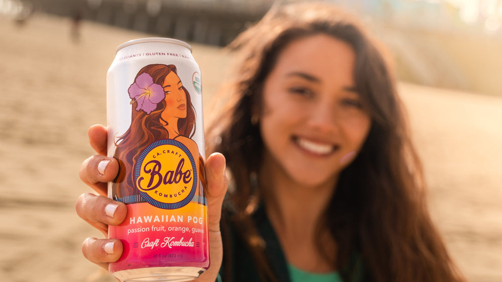 Girl holds Hawaiian POG Kombucha in the Park 