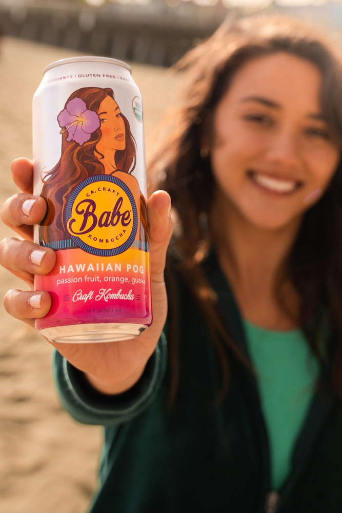 Girl holds Hawaiian POG Kombucha can